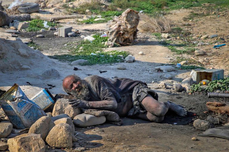 (FILES) In this file photo taken on December 28, 2018 Amou Haji (uncle Haji) lies on the ground on the outskirts of the village of Dezhgah in the Dehram district of the southwestern Iranian Fars province. An Iranian dubbed the 