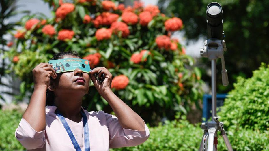 Una mujer observa el eclipse con protección visual