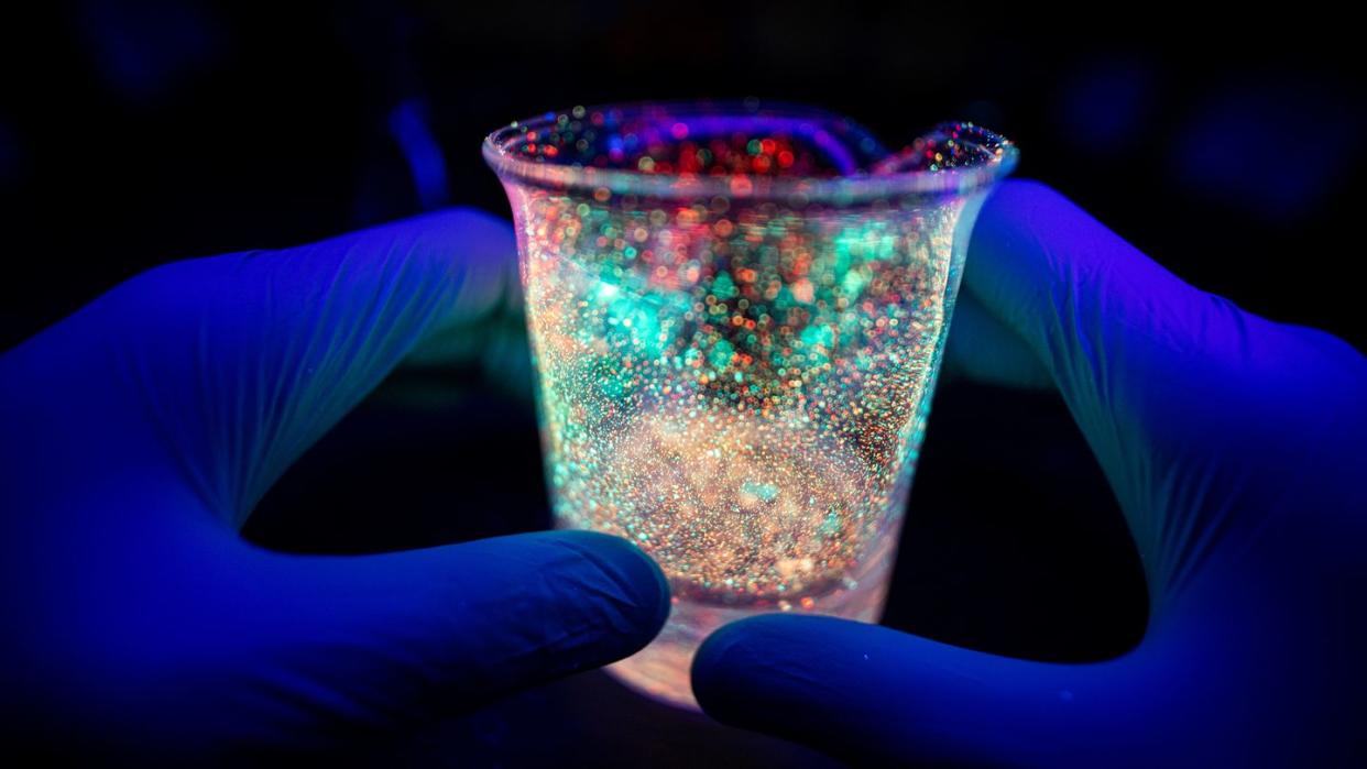 hand holding bacterial tube under uv light