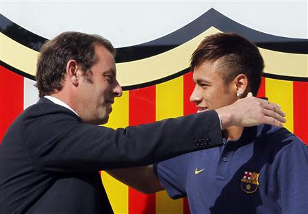 Brazilian soccer player Neymar (R) is embraced by Barcelona's president Sandor Rosell after signing a five-year contract with FC Barcelona, in front of their offices close to Camp Nou stadium in Barcelona in this June 3, 2013 file photo. REUTERS/Albert Gea