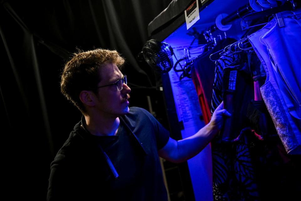 Laurence Christiansen, a local who works in wardrobe and shoes at Wharton shows, looks through some of the costumes backstage before a performance of the musical "Moulin Rouge" on Wednesday, April 10, 2024, at the Wharton Center in East Lansing.