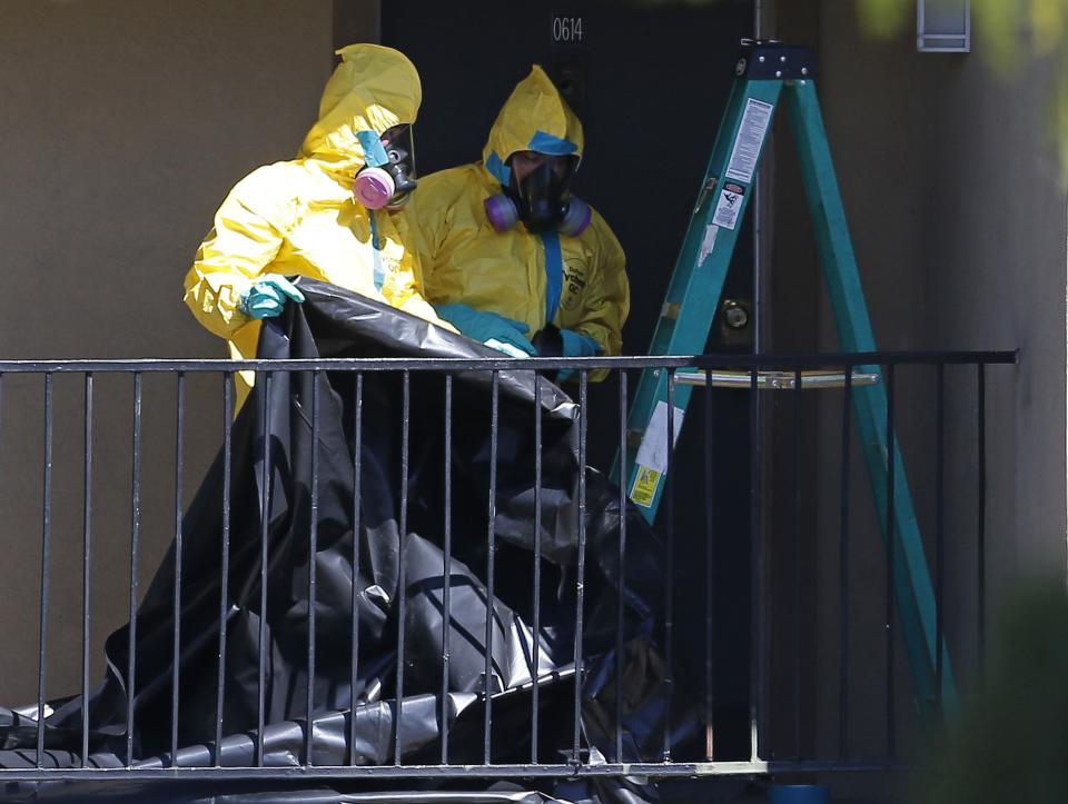 Workers wearing hazardous material suits arrive at the apartment unit where a man diagnosed with the Ebola virus was staying in Dallas, Texas, October 3, 2014. (REUTERS/Jim Young)