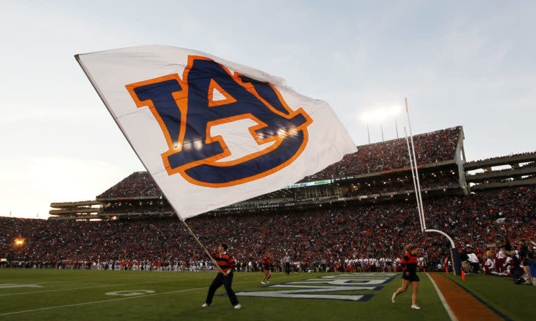 An Auburn supporter waves the flag on the field for the Tigers.