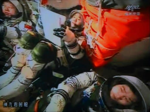 A screen grab taken from the large video screen at the Jiuquan Space Centre on June 29, 2012 shows Chinese astronauts in the Shenzhou-9 spacecraft as it prepared for reentry to earth's atmosphere
