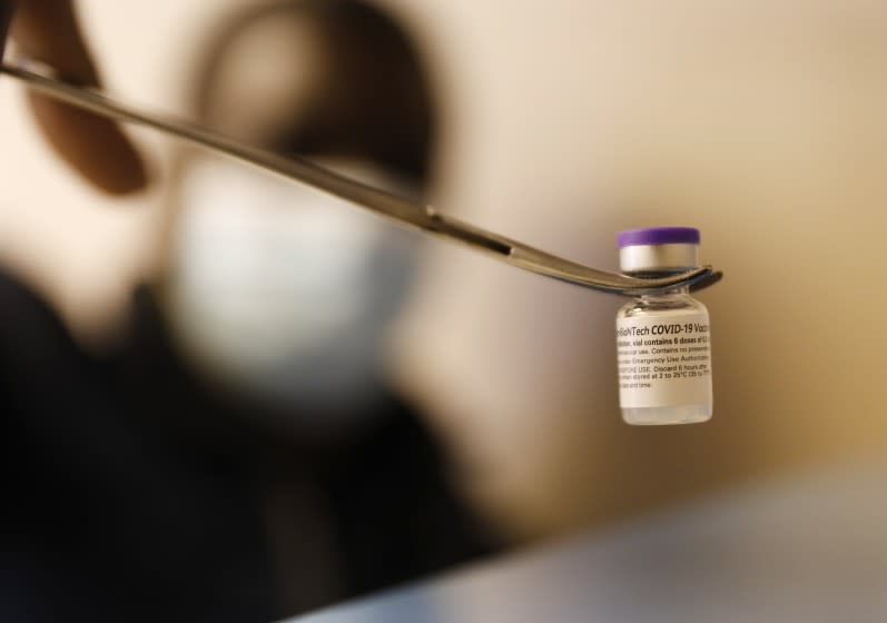 VERNON, CA - MARCH 23: Fredrick Agyin, Director Of Health And Environmental Control for the the city of Vernon displays one vial of the Pfizer COVID-19 vaccine which contains roughly 6 doses as they city is using a van to operate a mobile clinic and provide vaccination to frontline workers at various food and industrial plants in the city. The goal is to vaccinate about 11,000 workers. So far, it has vaccinated nearly 5,000 workers, all of who live in nearby neighborhoods in South L.A. and several cities in Southeast L.A. County. Vernon on Tuesday, March 23, 2021 in Vernon, CA. (Al Seib / Los Angeles Times).