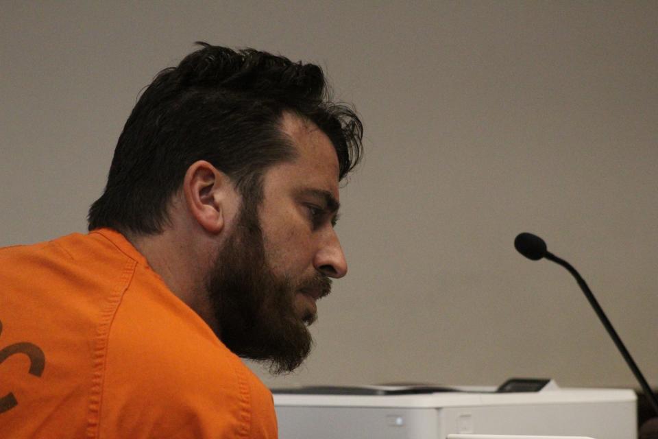 Arin Hankerd looks at evidence on the defense table during his hearing on Wednesday.