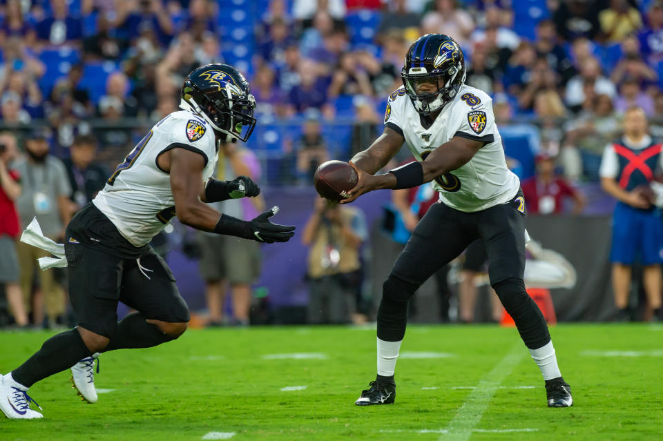 Baltimore Ravens quarterback Lamar Jackson (8) hands off to running back Mark Ingram (21)