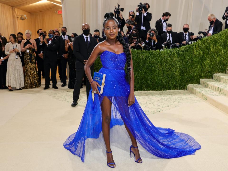 Amanda Gorman wears a blue dress on a red carpet.