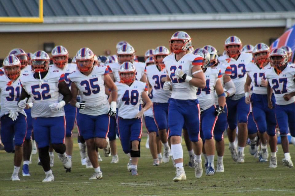 Bolles football players run onto the field ahead of the matchup against Oakleaf.