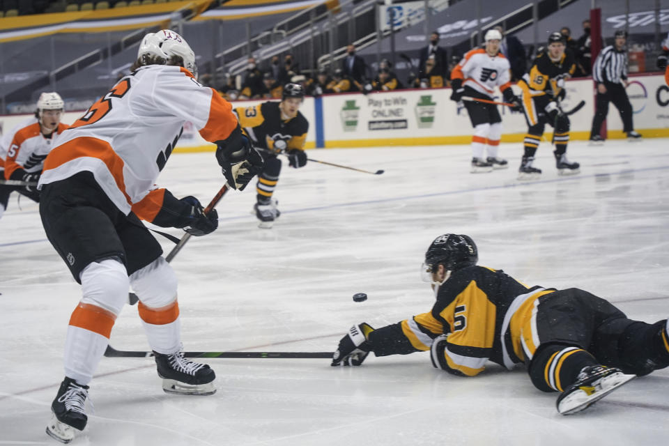 Pittsburgh Penguins' Mike Matheson (5) dives trying to stop a pass to Philadelphia Flyers' Joel Farabee, left, during the second period of an NHL hockey game, Tuesday, March 2, 2021, in Pittsburgh. Farabee got the puck and then scored on the play. (AP Photo/Keith Srakocic)