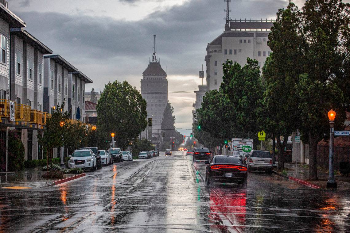 Cars driving into downtown as a late-season storm front brings rain to Fresno Monday evening on March 28, 2022.