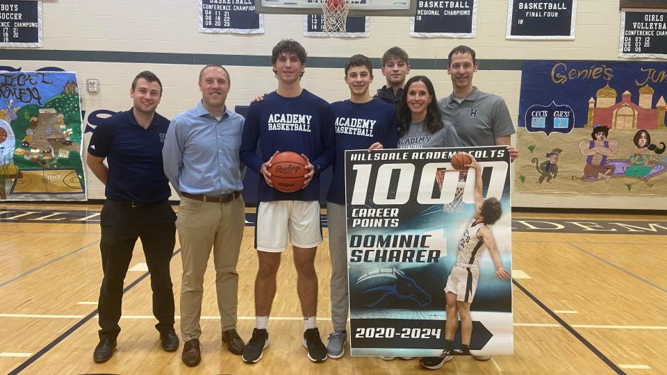 Hillsdale Academy senior Dominic Scharer celebrates his career milestone with (from left to right) coach and A.D. Nathan Naveau, head coach Zach Miller, brothers Dawson and Damion Scharer, and parents Dustin and Heather Scharer.