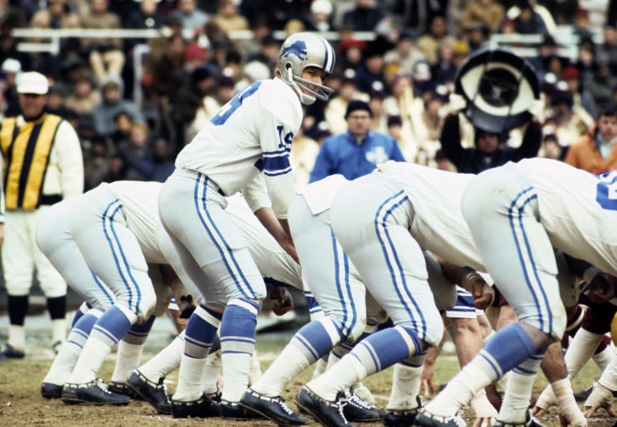 Bill Munson places his hands under center as the Lions prepare to snap the ball.
