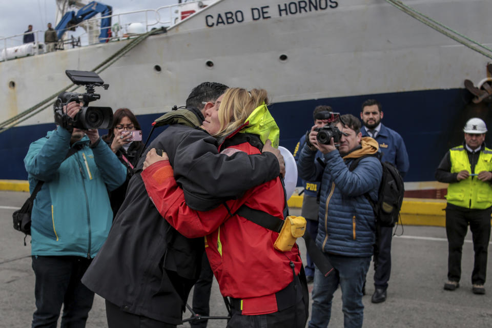 La velerista británica Susie Goodall abraza al comandante de la Armada chilena Carlos Cerda después de desembarcar del buque de carga MV Tian Fu en Punta Arenas, Chile, el viernes 14 de diciembre de 2018. El buque de carga rescató a Goodall la semana pasada después de que una violenta tormenta arrancara el mástil de su yate. (AP Foto / Joel Estay)