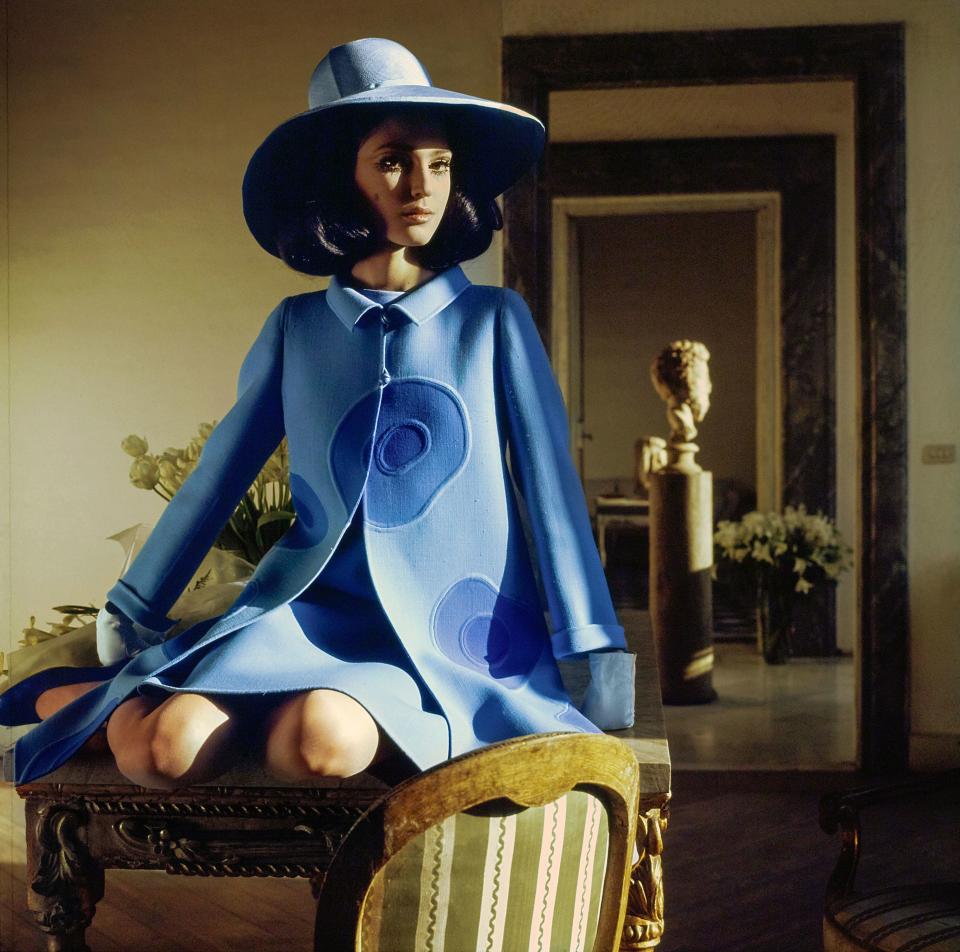 Benedetta Barzini wears “intarsia anemones from Mila Schön, big, stylized, set into a double-face wool coat of pale blue, the flowers deeper blue. The straw hat is by Mila Schön.”​