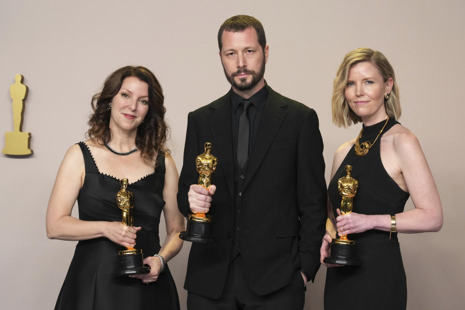 Raney Aronson-Rath, de izquierda a derecha, Mstyslav Chernov, y Michelle Mizner posan en la sala de prensa con el premio a mejor largometraje documetnal por "20 Days in Mariupol" en los Oscar el domingo 10 de marzo de 2024, en el Teatro Dolby en Los Ángeles. (Foto Jordan Strauss/Invision/AP)