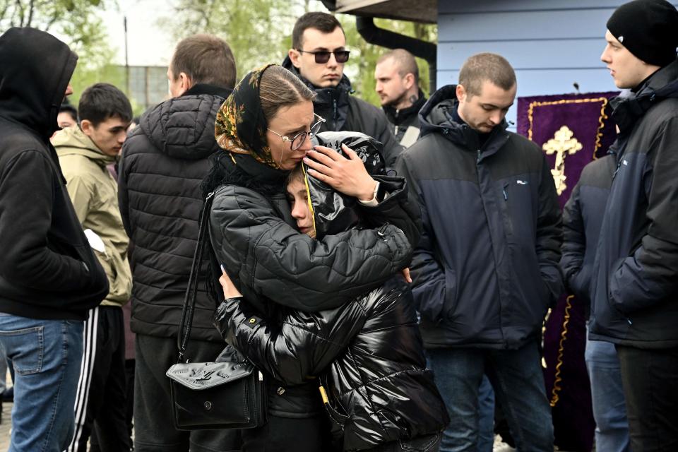 People embrace each other during the funeral service of Shulga Sophiya, 11, and her brother Pisarev Kiryusha, 17, who were killed after a Russian missile strike on a multistorey residential building, at a church in Uman (AFP via Getty Images)