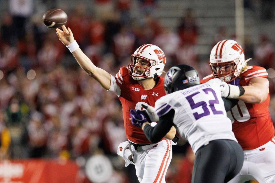 Nov 11, 2023; Madison, Wisconsin, USA; Wisconsin Badgers quarterback Tanner Mordecai (8) throws a pass under pressure from Northwestern Wildcats defensive lineman Richie Hagarty (52) during the fourth quarter at Camp Randall Stadium. Mandatory Credit: Jeff Hanisch-USA TODAY Sports