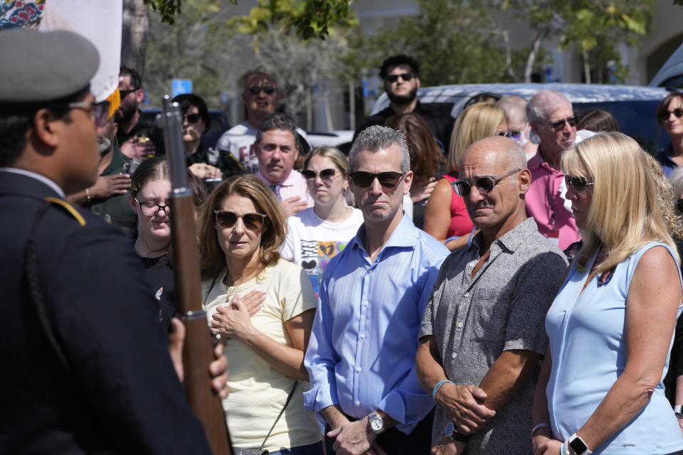 Family members of the Parkland, Fla., shooting stand during the singing of the National Anthem, Tuesday, Feb. 14, 2023, at a ceremony in Coral Springs, Fla., honoring the lives of the 17 students and staff of Marjory Stoneman Douglas High School that were killed on Valentine's Day, 2018. (AP Photo/Wilfredo Lee)