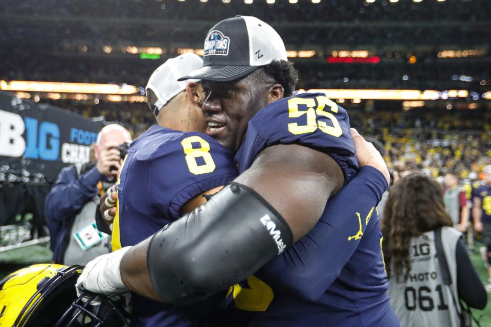 Michigan wide receiver Ronnie Bell (8) hugs offensive lineman Olusegun Oluwatimi (55) after winning the Big Ten Championship Lucas Oil Stadium in Indianapolis, Ind., on Saturday, Dec. 3, 2022.