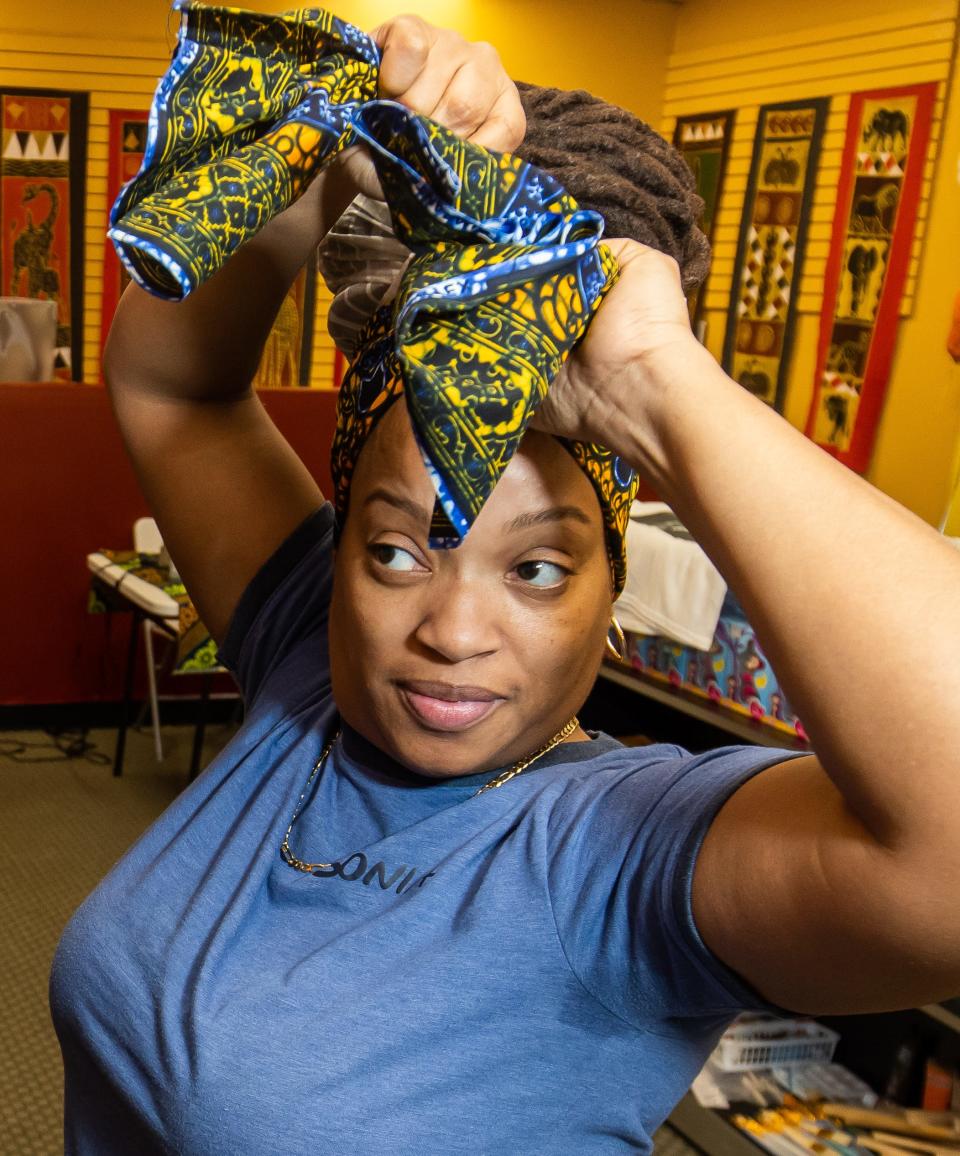 Sonia Williams tries on a hair scarf while shopping at the Abantu African Consignment Outlet on Jan. 20.
