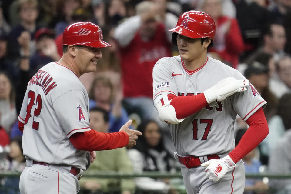 Los Angeles Angels' Shohei Ohtani (17) is congratulated by third base coach Bill Haselman after hitting a solo home run during the third inning of a baseball game against the Milwaukee Brewers, Sunday, April 30, 2023, in Milwaukee. (AP Photo/Aaron Gash)