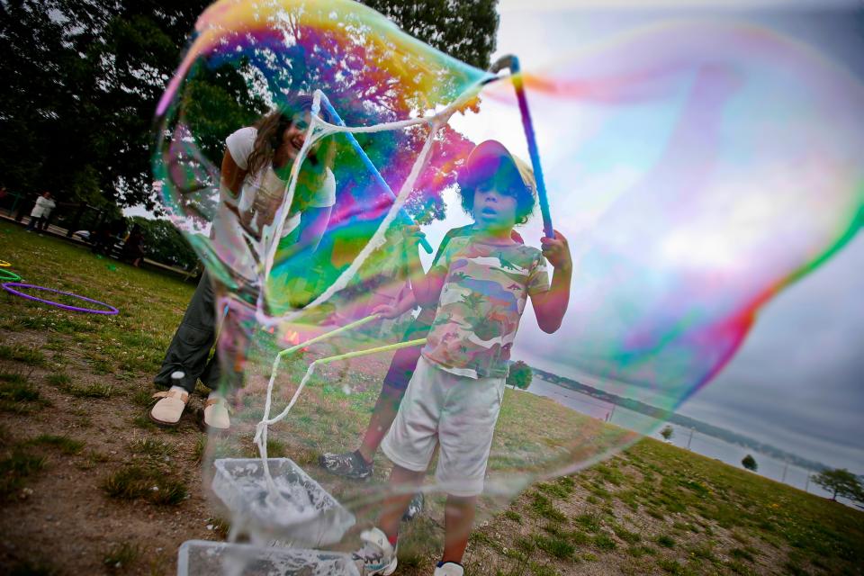 Adriane Perdomo, 7, blows a soap bubble at the Play in the Park program which kicked off Monday, June 26, at Hazelwood Park in New Bedford.