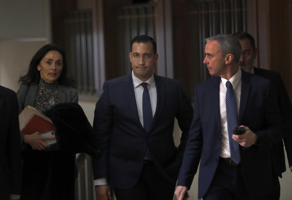 Former President Macron's security aide Alexandre Benalla, center, leaves the French Senate Laws Commission after his hearing, in Paris, Monday, Jan. 21, 2019. Benalla has been taken into police custody last week in an investigation of possible misuse of diplomatic passports and then released. (AP Photo/Christophe Ena)