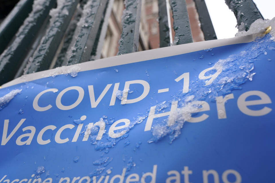 A sign covered with ice advertises a COVID-19 vaccination site in New York, Tuesday, Feb. 2, 2021. The site was closed today due to the inclement weather. Coronavirus vaccination sites across the Northeastern U.S. are getting back up and running after a two-day snowstorm that also shut down public transport, closed schools and canceled flights. Some vaccination sites in New York City remained closed, but others, including those run by the public hospital system, were open Tuesday. (AP Photo/Seth Wenig)