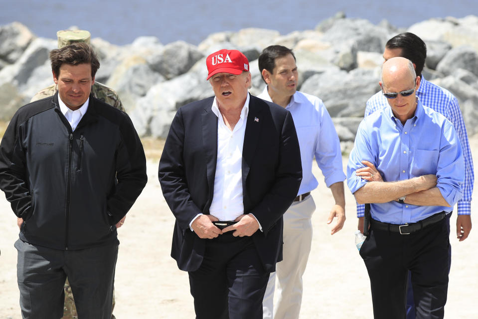 President Donald Trump walks with Florida Gov. Ron DeSantis, Sen. Marco Rubio and Sen. Rick Scott during a visit to Canal Point, Florida, on Friday, March 29, 2019. / Credit: Manuel Balce Ceneta / AP