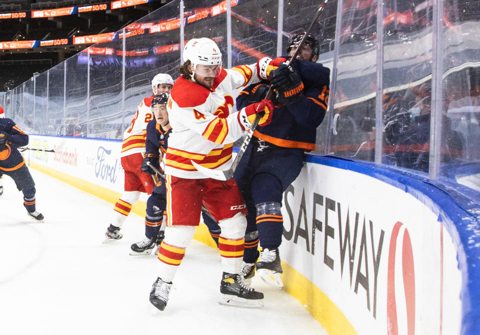 Edmonton Oilers' James Neal (18) is checked by Calgary Flames' Rasmus Andersson (4) during the second period of an NHL hockey game, Thursday, April 29, 2021 in Edmonton, Alberta. (Jason Franson/Canadian Press via AP)