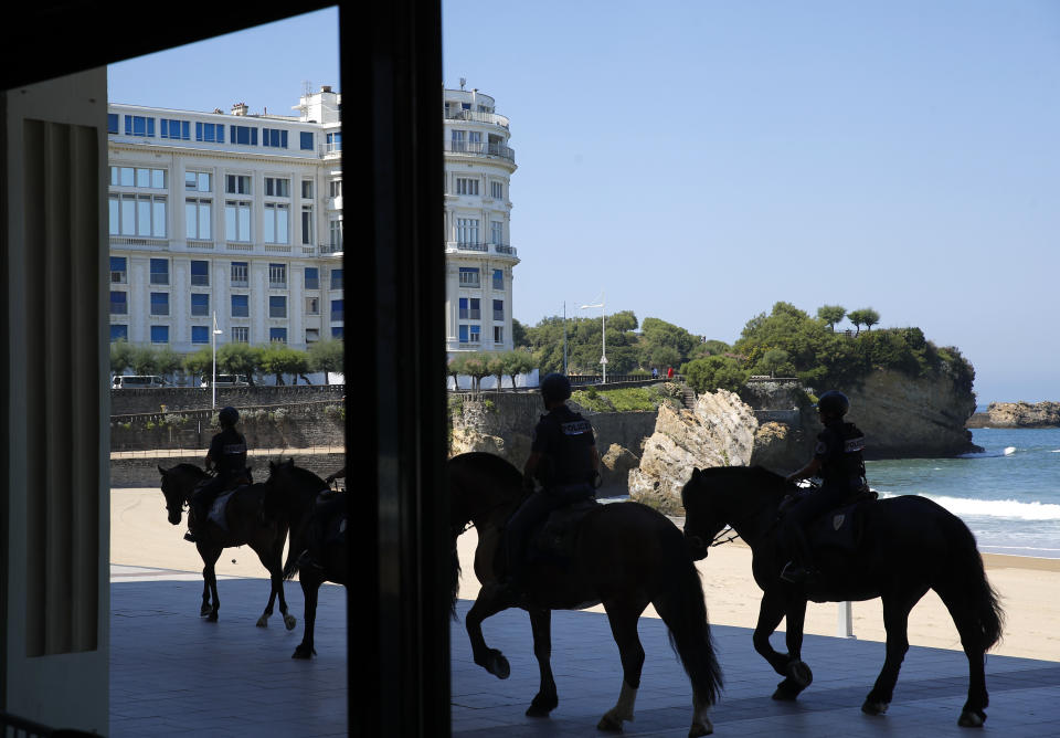 Mounted police officers patrol along the beach, with the G7 venue Bellevue in background, Saturday, Aug. 24, 2019 in Biarritz. Leaders of the Group of Seven countries arrive on Saturday to discuss issues including the struggling global economy and climate change until Monday. They include the United States, Germany, Japan, Britain, France, Canada and Italy. (AP Photo/Francois Mori)