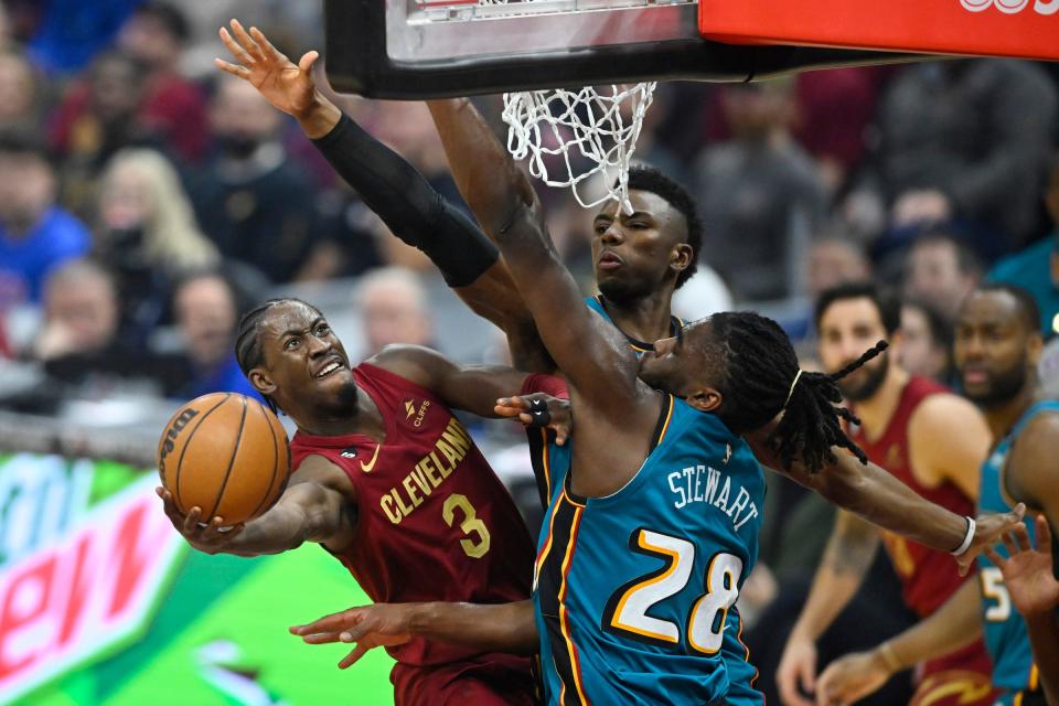 Cavaliers guard Caris LeVert shoots beside Pistons guard Hamidou Diallo, back, and center Isaiah Stewart during the first half on Wednesday, Feb. 8, 2023, in Cleveland.