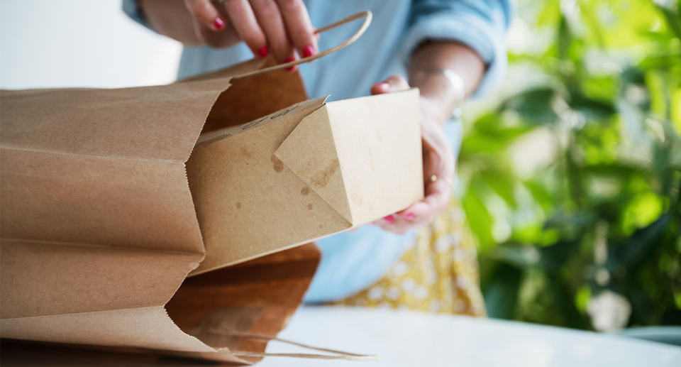 Person opening takeaway box at home. (Getty Images)