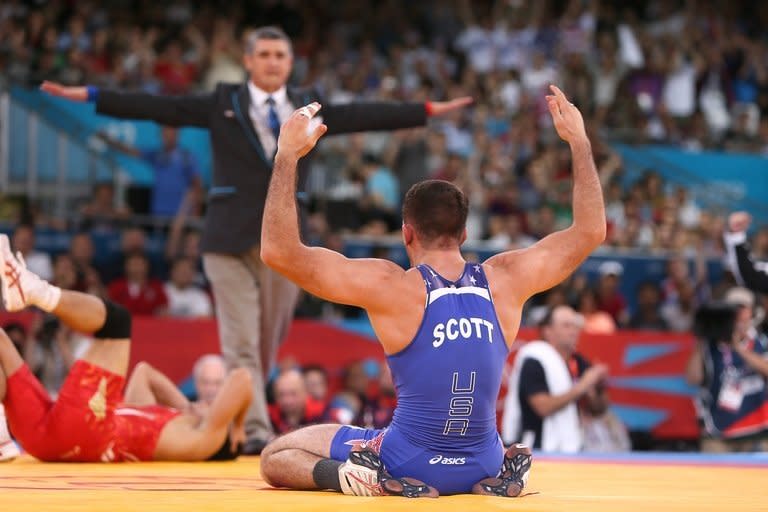 American Coleman Scott (R) celebrates winning the Men's 60kg Freestyle bronze medal match on August 11, 2012 during the wrestling event of the London 2012 Olympic Games. "We have to bond as a worldwide community to keep wrestling in the Games," said Scott