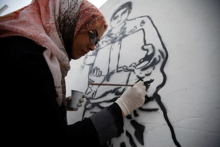 An artist paints a mural as part of the "Silent Victims" campaign to depict the suffering of women and children in the war-torn Yemen, in Sanaa, Yemen March 1, 2018. REUTERS/Mohamed al-Sayaghi