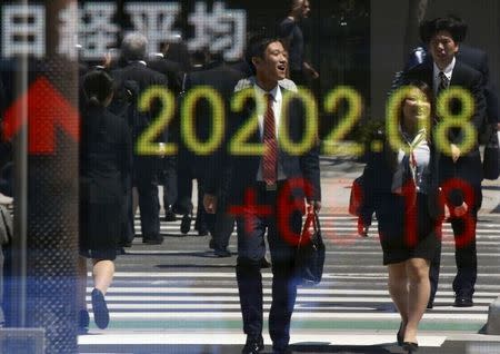 People are reflected in an electronic board displaying Japan's Nikkei share average outside a brokerage in Tokyo April 23, 2015. REUTERS/Toru Hanai