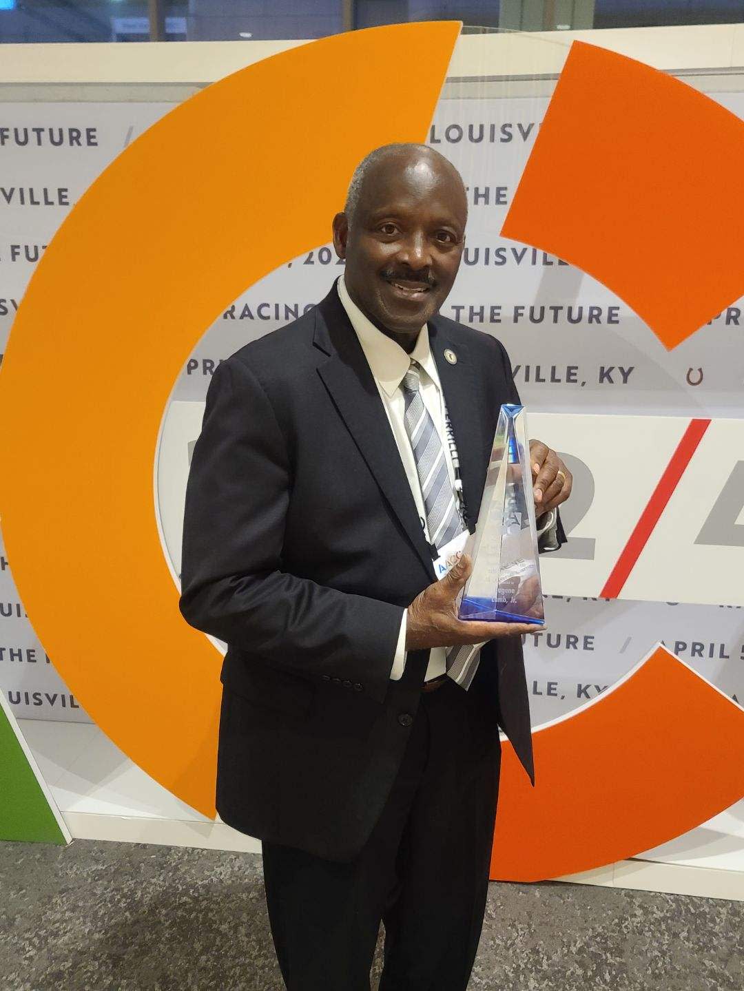 TCC Trustee Eugene Lamb holds his Trustee of the Year award from AACC.