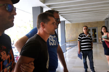 Alexander Vinnik, a 38 year old Russian man (2nd L) suspected of running a money laundering operation, is escorted by plain-clothes police officers to a court in Thessaloniki, Greece July 26, 2017. REUTERS/Alexandros Avramidis