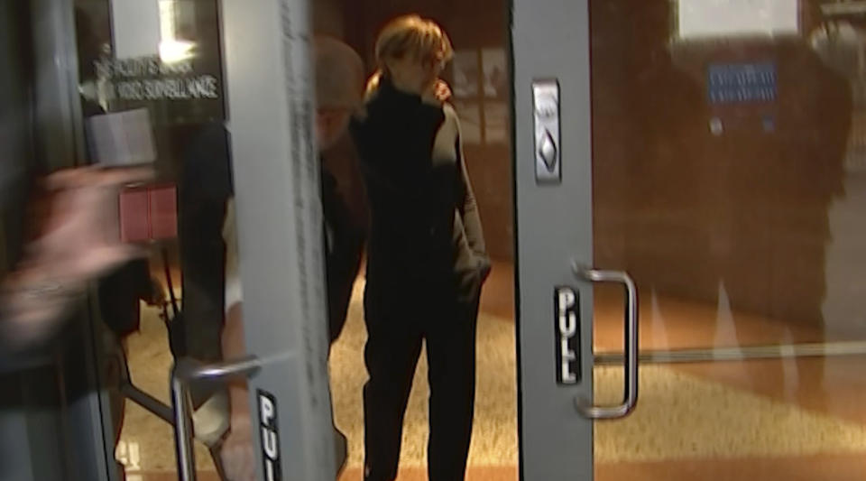 In this still image taken from video, actress Felicity Huffman walks towards the door in the lobby of a Los Angeles court after she is released on a $250,000 bond, Tuesday, March 12, 2019. Huffman is among 50 people charged in a scheme in which wealthy parents allegedly bribed college coaches and other insiders to get their children into some of the nation's most selective schools. (AP Photo/Rick Taber)