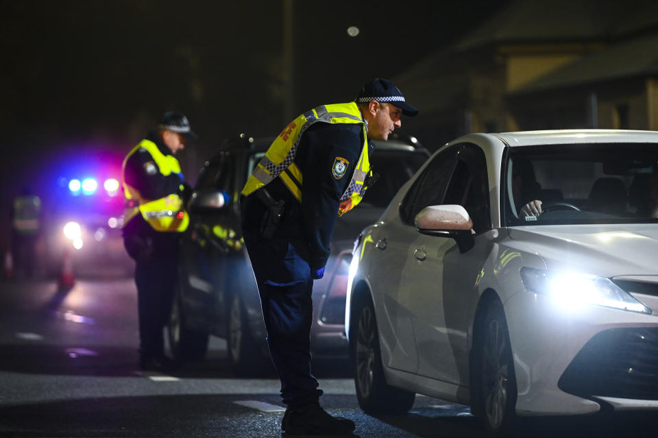 NSW Police officers speak to drivers crossing the border between NSW and Victoria in the NSW-Victoria border town of Albury, NSW, Tuesday, July 7, 2020.