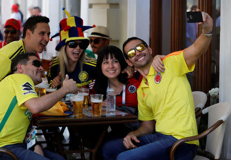 Supporters of the Colombian national soccer team take a selfie as they rest at a cafe in central Moscow, Russia June 18, 2018. REUTERS/Tatyana Makeyeva