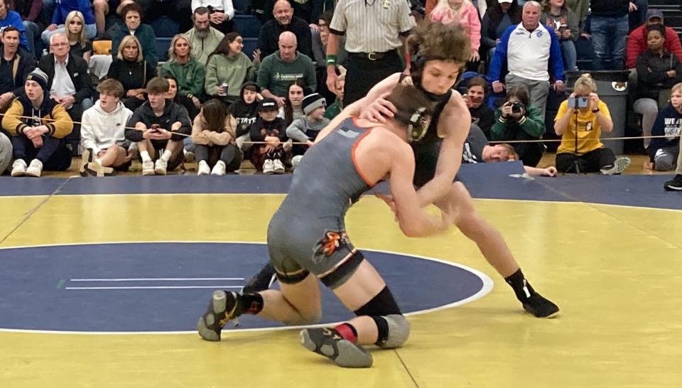 St. Vincent-St. Mary's Bryce Skinner engages with Howland's Adam Heckman in the 126-pound final Saturday at district tournament at Garfield Heights.