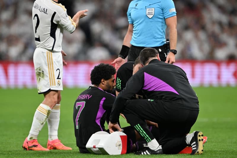 Munich's Serge Gnabry (C) lies injured on the ground during the UEFA Champions League semi-final, second leg match between Real Madrid and Bayern Munich at the Santiago Bernabeu. Peter Kneffel/dpa