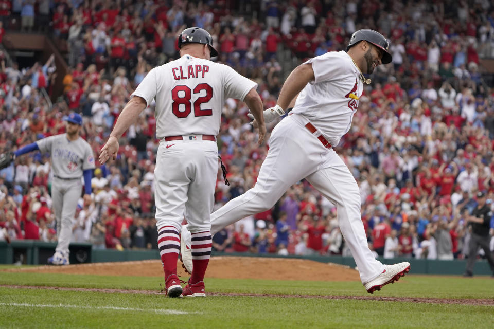 St. Louis Cardinals' Albert Pujols, right, is congratulated by first base coach Stubby Clapp (82) after hitting a two-run home run off Chicago Cubs relief pitcher Brandon Hughes, left, during the eighth inning of a baseball game Sunday, Sept. 4, 2022, in St. Louis. (AP Photo/Jeff Roberson)
