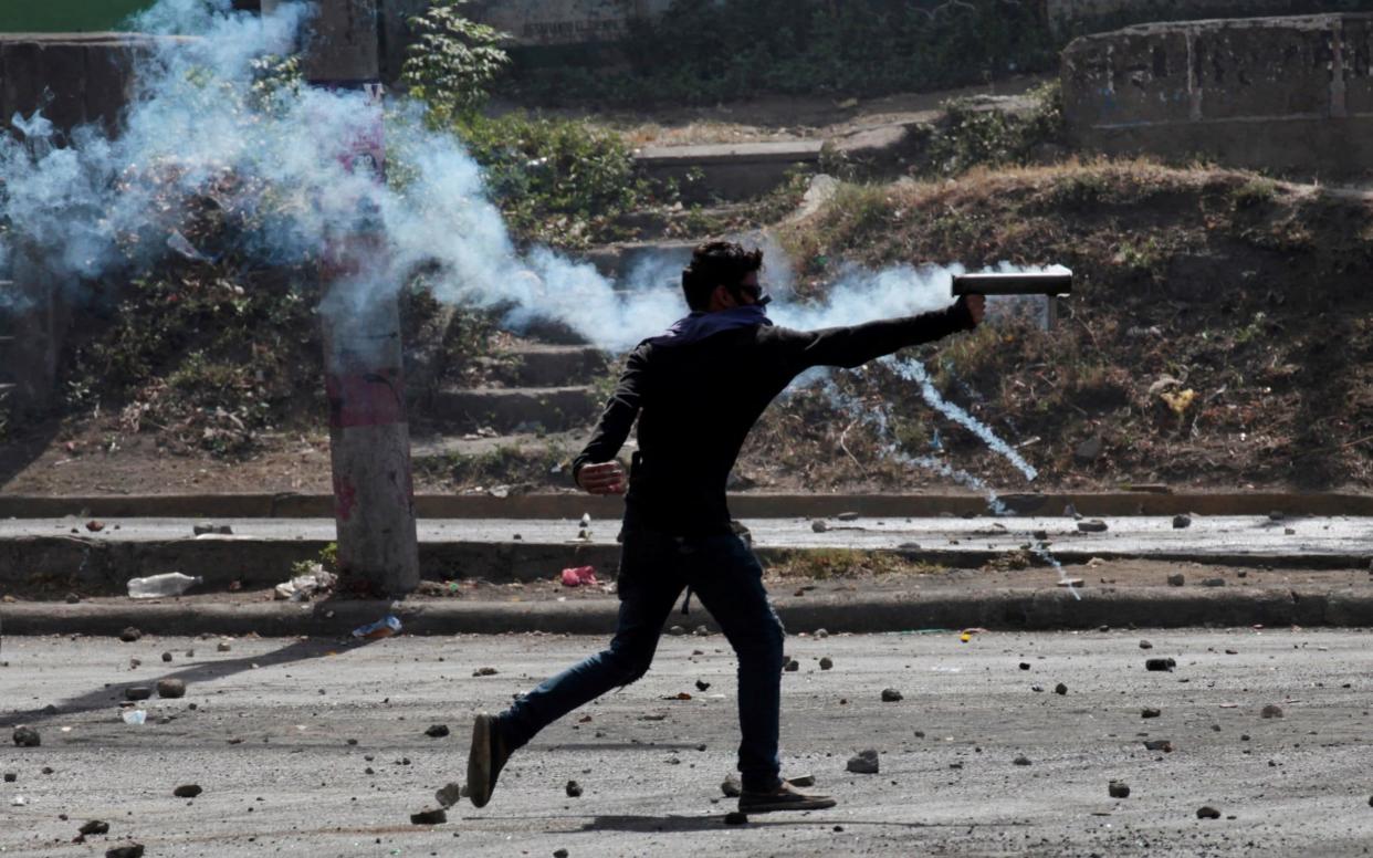 A demonstrator fires a homemade mortar towards riot police during a protest in Managua - REUTERS