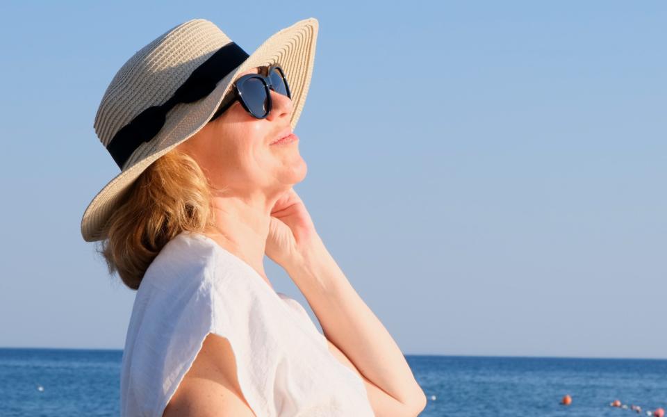 Woman wearing a sunhat to prevent a sunburned scalp