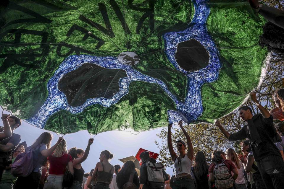 Climate change activists float a banner for earth's rivers during a climate strike rally, as part of a global youth-led day of global action, Friday Sept. 20, 2019, in New York. (AP Photo/Bebeto Matthews)