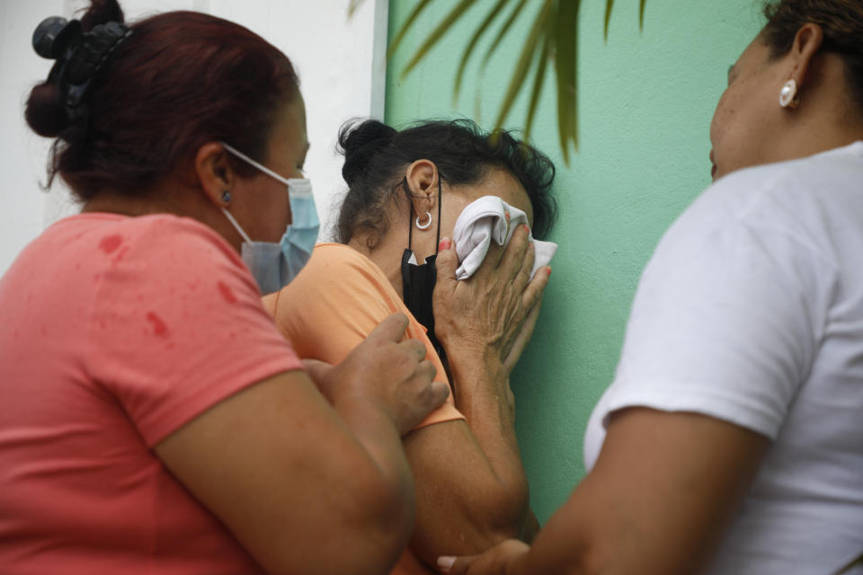 Relatives of inmates wait in distress outside the entrance to the women's prison in Tamara, on the outskirts of Tegucigalpa, Honduras, Tuesday, June 20, 2023. A riot at the women's prison has left at least 41 inmates dead, most of them burned to death, a Honduran police official said. (AP Photo/Elmer Martinez)