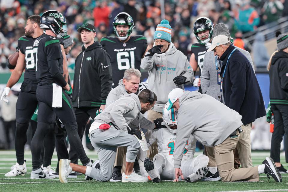 Dolphins coach Mike McDaniel speaks with Jaelan Phillips after Phillips injured his Achilles against the Jets.